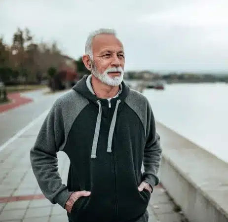 Cette image montre un homme agées portant une montre pour Alzheimer qui fait aussi GPS.